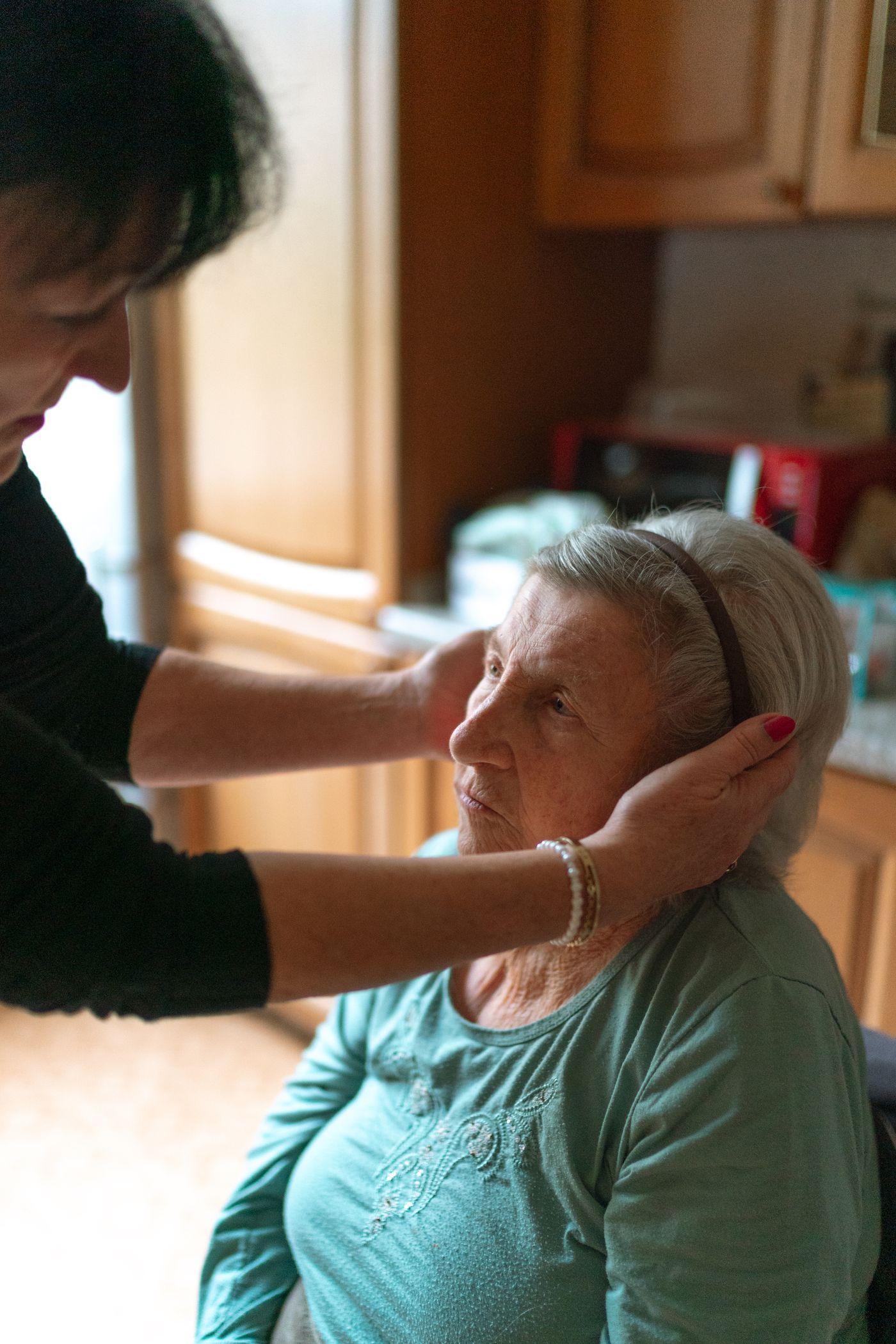 A CaringPlus caregiver gently assisting a senior woman